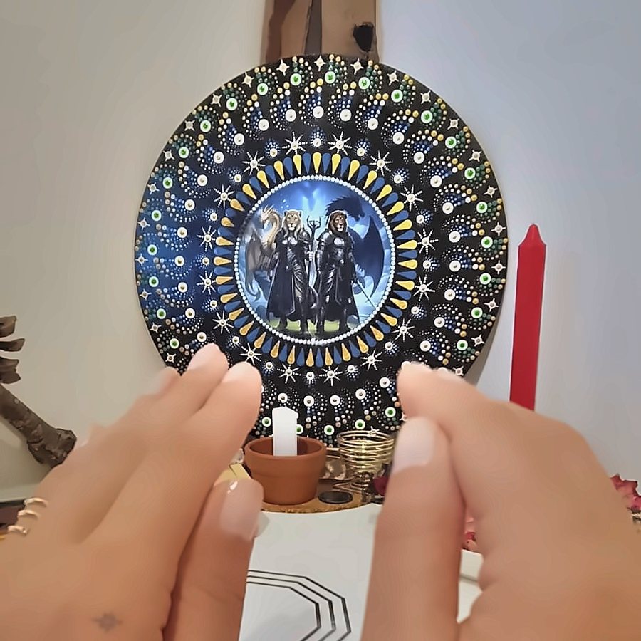 Mãos de Juliana Vilaça sobre uma mandala pintada, antes de iniciar um atendimento